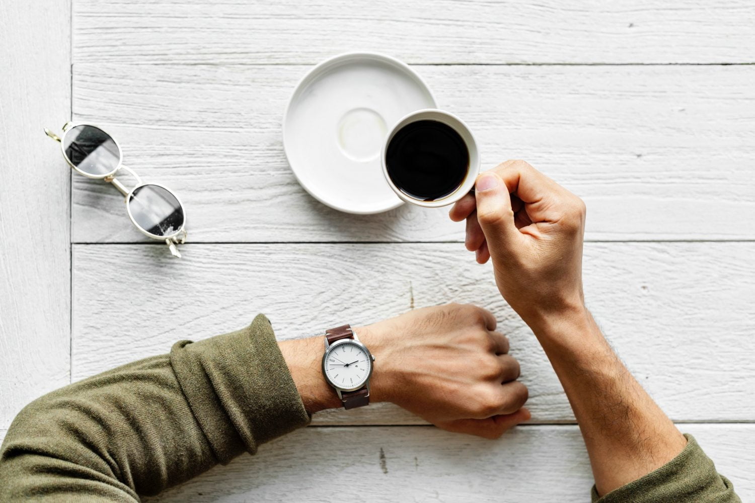 Man met horloge en kopje koffie